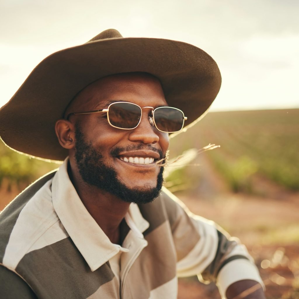 Farm, agriculture and sustainability with a black man farmer outdoor on a grass field or land for o